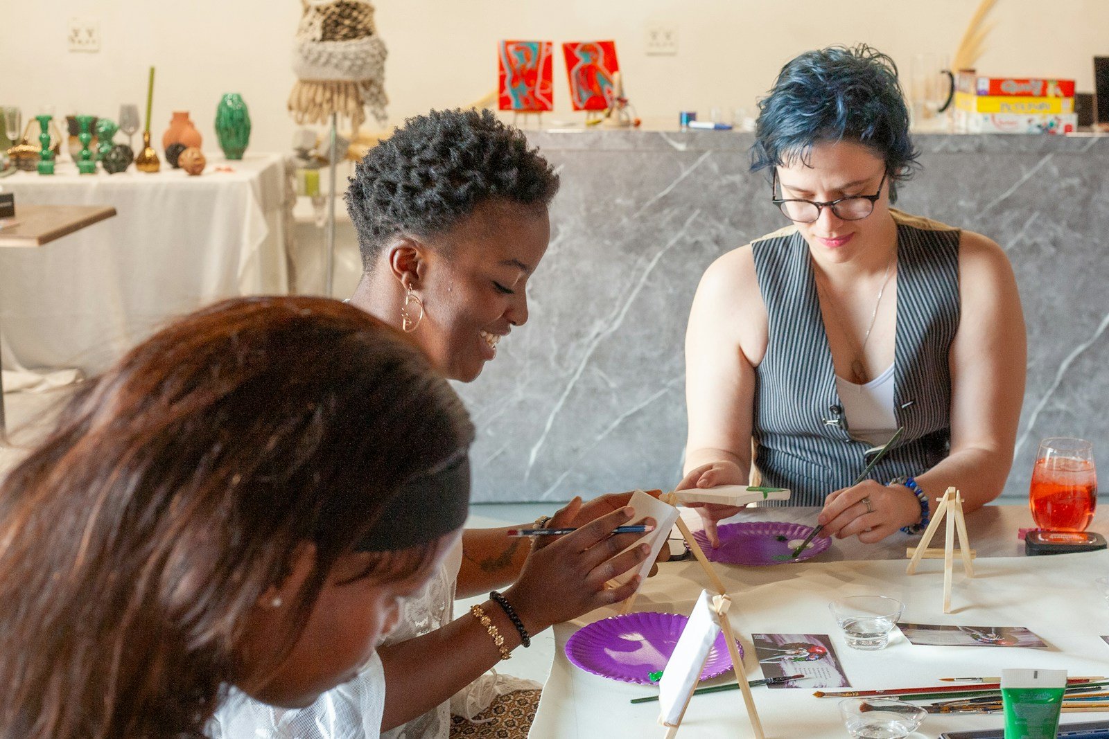 Trois femmes peignant et créant autour d’une table